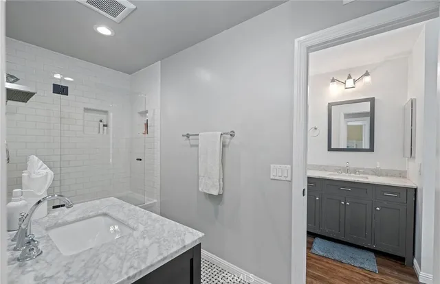a en suite bathroom with a granite countertop sink and a mirror