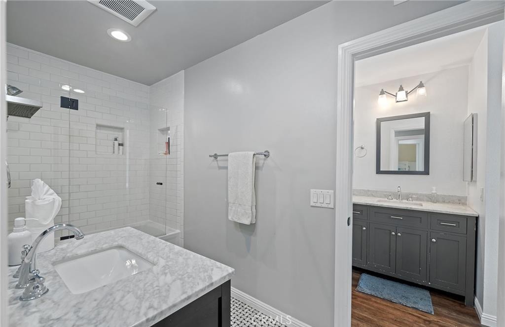 164 Stanford Court, Unit 82 Irvine, CA 92612 - Photo 23 of 34 a en suite bathroom with a granite countertop sink and a mirror
