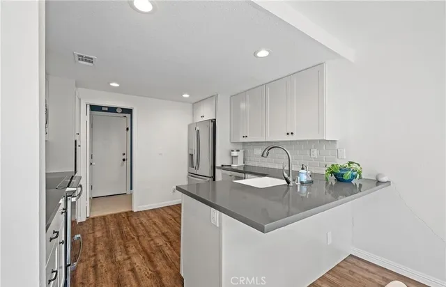 a kitchen with stainless steel appliances granite countertop a sink a stove and a refrigerator