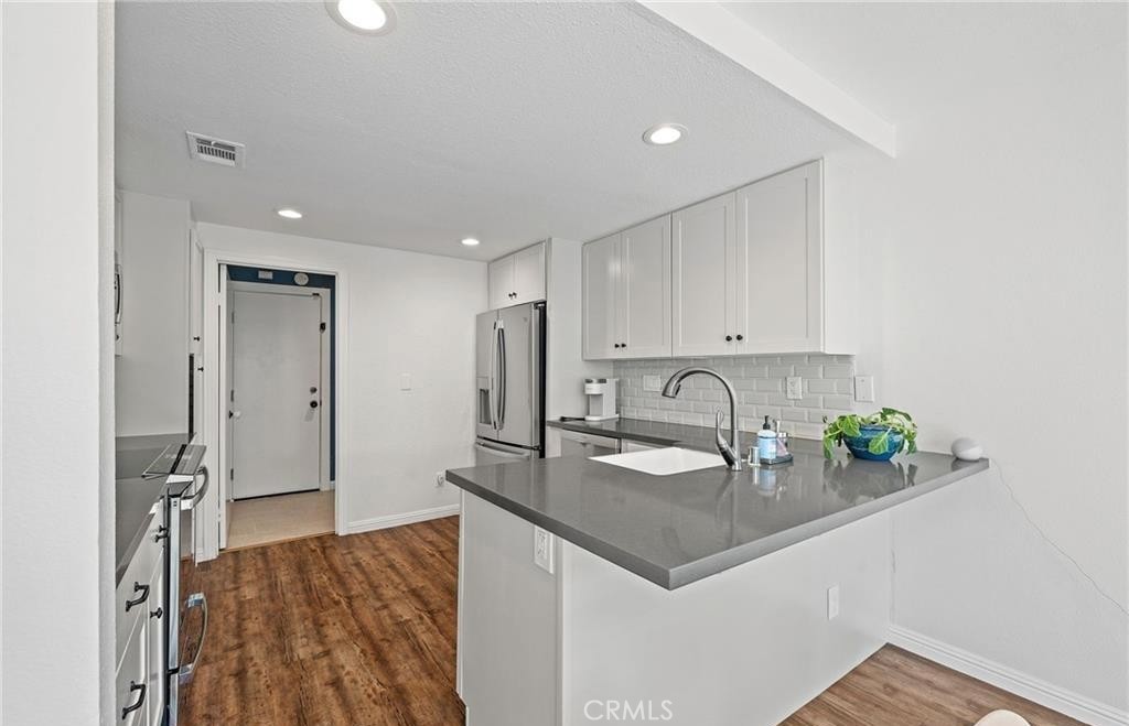 164 Stanford Court, Unit 82 Irvine, CA 92612 - Photo 7 of 34 a kitchen with stainless steel appliances granite countertop a sink a stove and a refrigerator