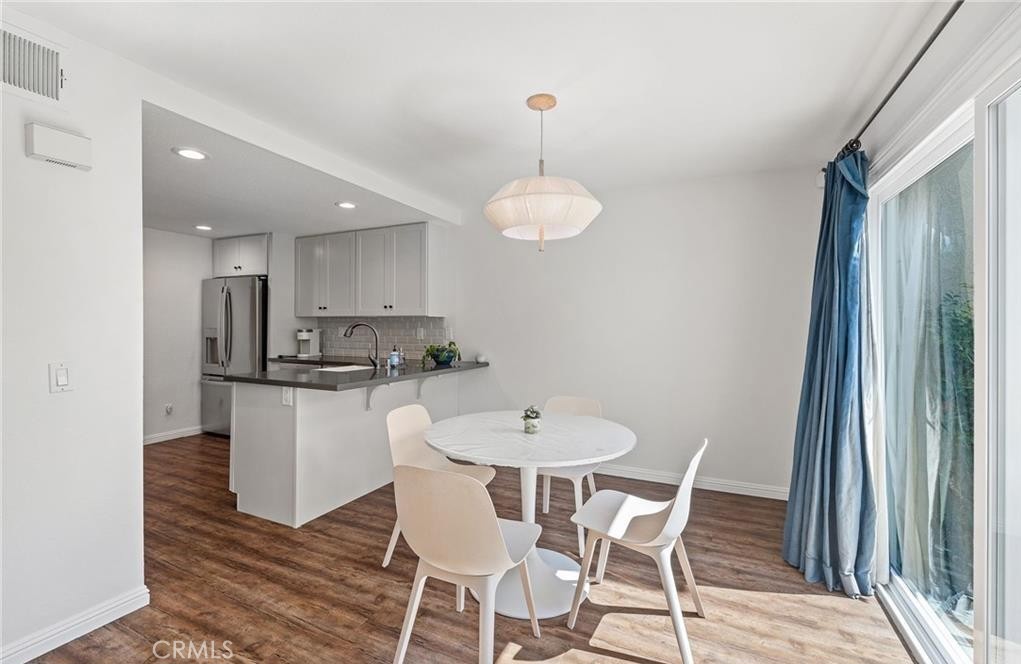 164 Stanford Court, Unit 82 Irvine, CA 92612 - Photo 9 of 34 a view of a dining room with furniture and wooden floor