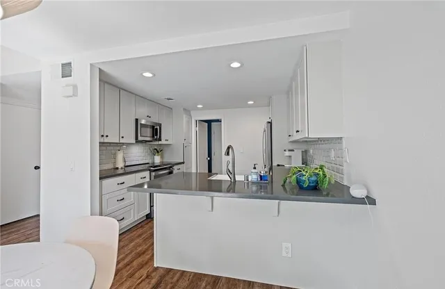 a kitchen with stainless steel appliances a sink stove and cabinets