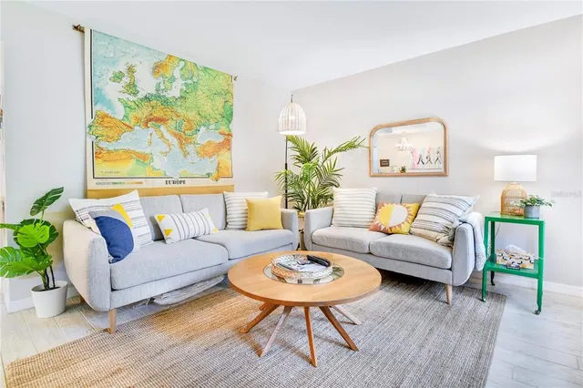 a living room with furniture and a painting on the wall