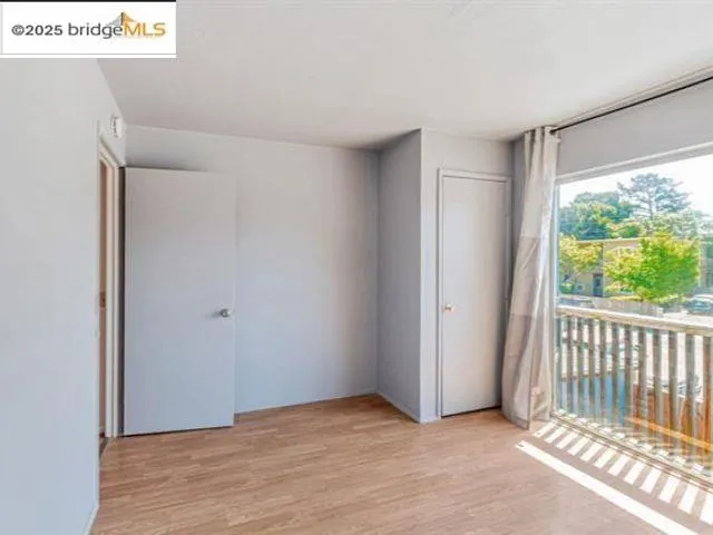 a view of a livingroom with wooden floor and a window