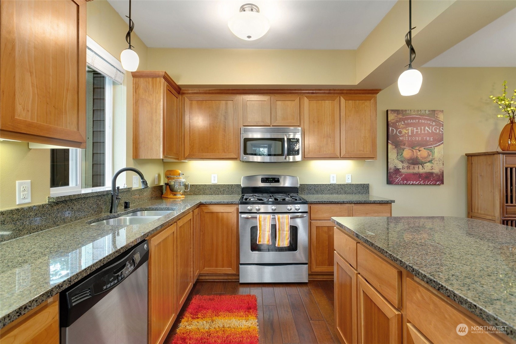 4600 Northeast 3rd Lane, Unit E1 Renton, WA 98059 - Photo 10 of 35 a kitchen with stainless steel appliances granite countertop a sink a stove and a wooden floors