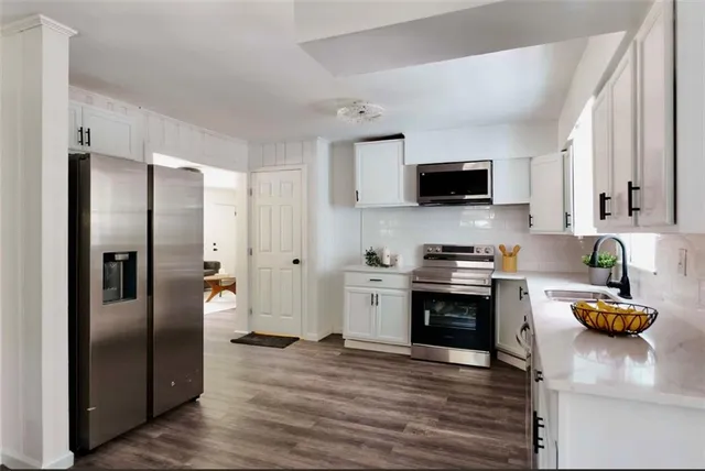 a kitchen with stainless steel appliances granite countertop a refrigerator a stove top oven a sink and dishwasher