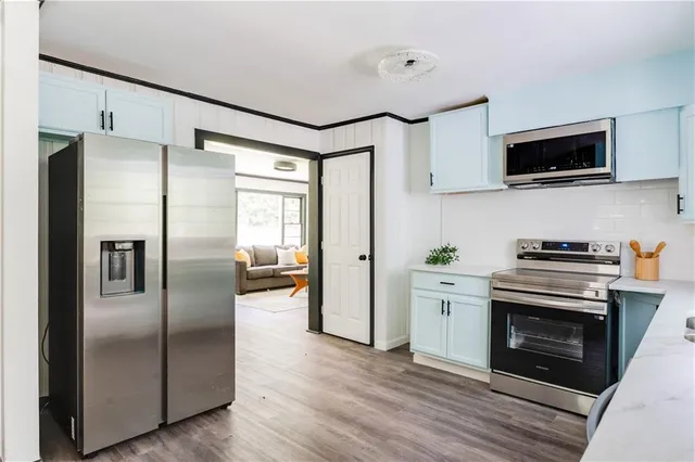 a kitchen with stainless steel appliances a refrigerator a stove top oven a sink and dishwasher