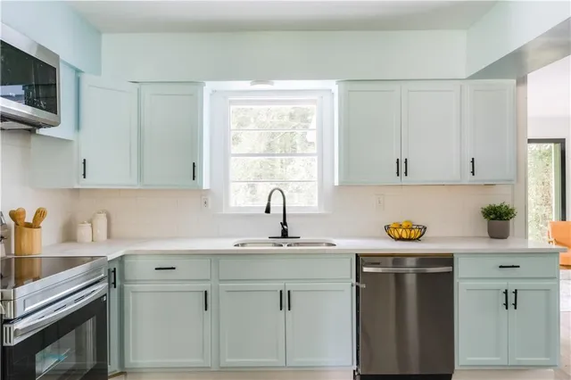 a kitchen with white cabinets and white appliances