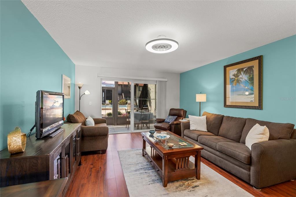 1630 Stickney Point Road, Unit 101 Sarasota, FL 34231 - Photo 11 of 40 a living room with furniture wooden floor and a flat screen tv