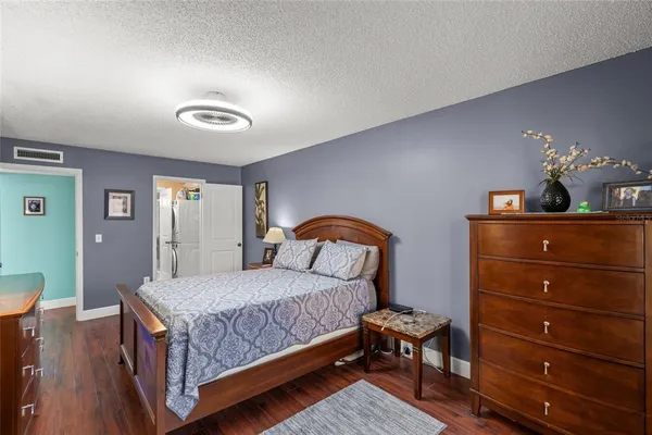 a bedroom with a bed and a dresser with mirror