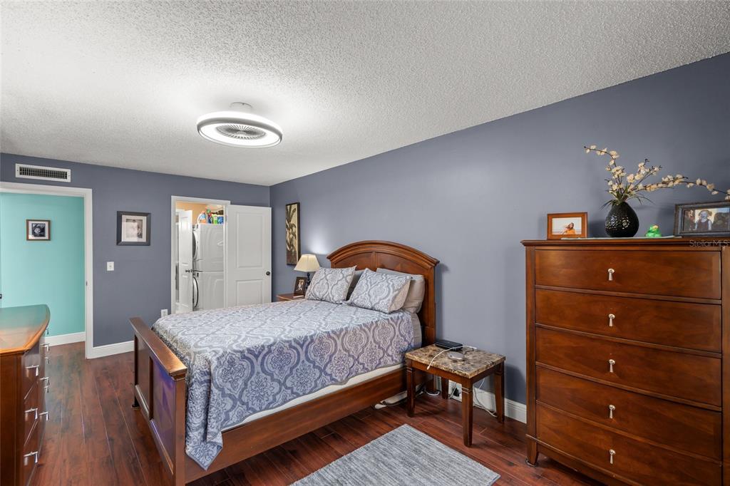 1630 Stickney Point Road, Unit 101 Sarasota, FL 34231 - Photo 16 of 40 a bedroom with a bed and wooden floor