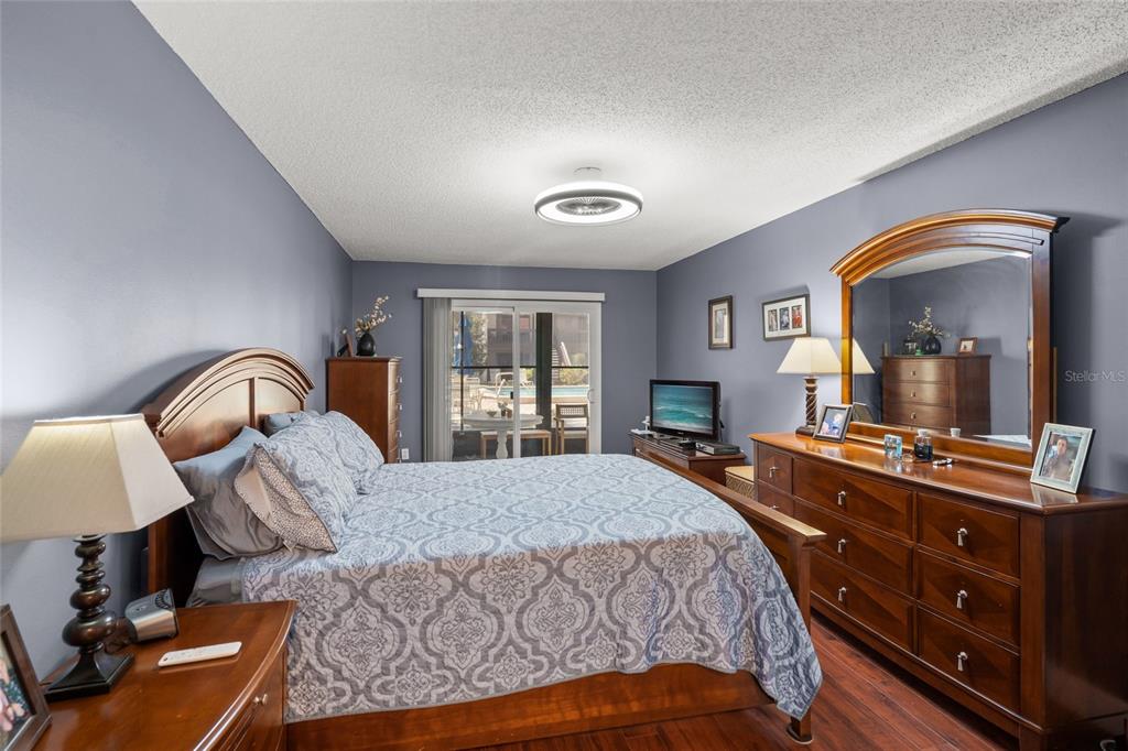 1630 Stickney Point Road, Unit 101 Sarasota, FL 34231 - Photo 17 of 40 a bedroom with a bed and a dresser with mirror