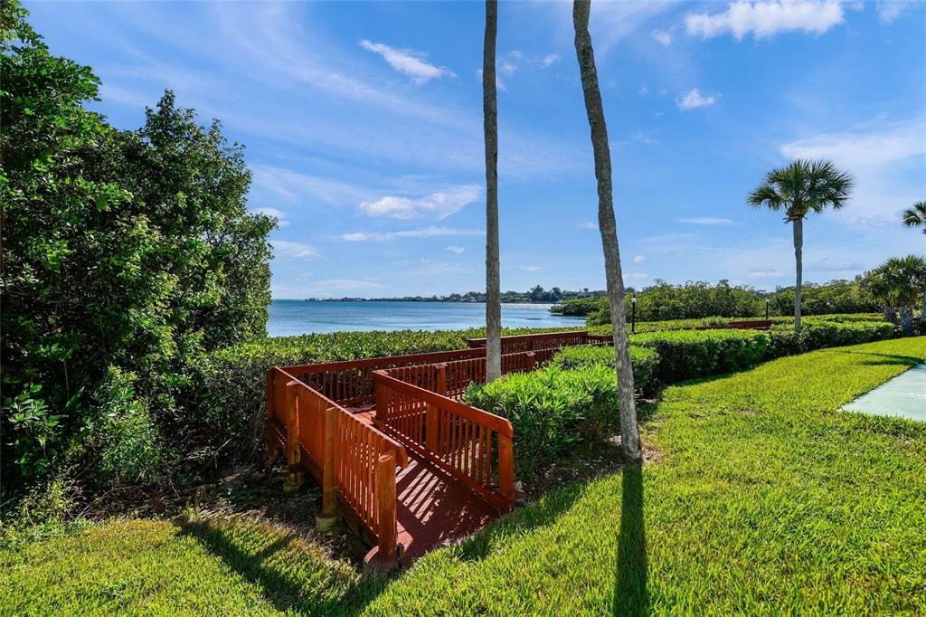 1630 Stickney Point Road, Unit 101 Sarasota, FL 34231 - Photo 29 of 40 a view of a garden with a bench in the background