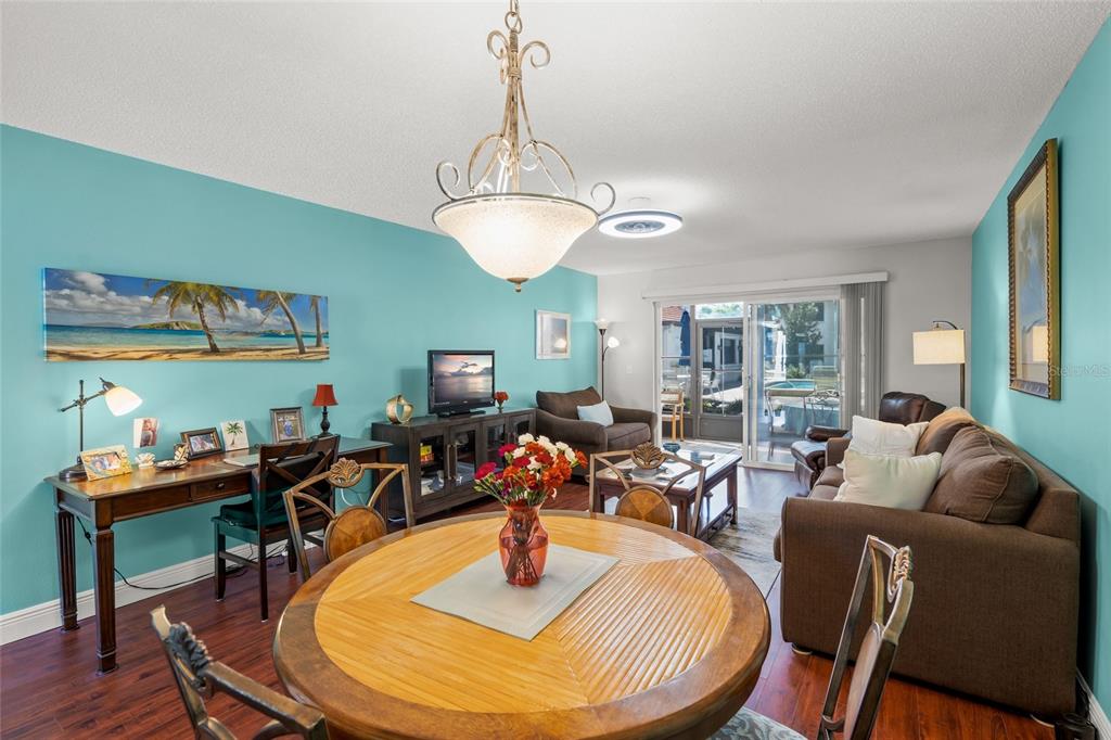 1630 Stickney Point Road, Unit 101 Sarasota, FL 34231 - Photo 10 of 40 a living room with furniture a dining table and a chandelier