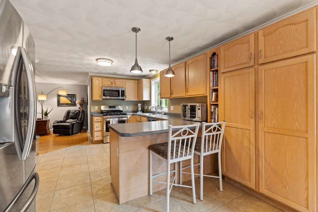 9 Campbell Road Billerica, MA 01821 - Photo 14 of 31 a kitchen with stainless steel appliances granite countertop a refrigerator a sink dishwasher a stove and a refrigerator with wooden floor
