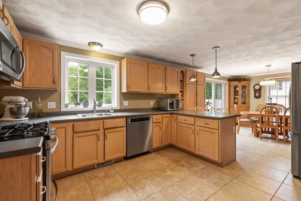 9 Campbell Road Billerica, MA 01821 - Photo 16 of 31 a kitchen with stainless steel appliances granite countertop a stove a sink and a microwave