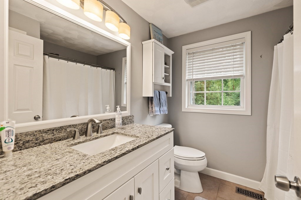 9 Campbell Road Billerica, MA 01821 - Photo 23 of 31 a bathroom with a granite countertop sink toilet and mirror