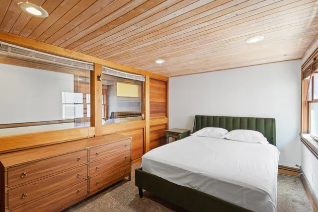 a large bed sitting in a bedroom next to a window