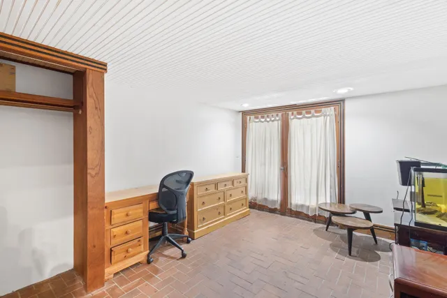 a view of a workspace with furniture and a window