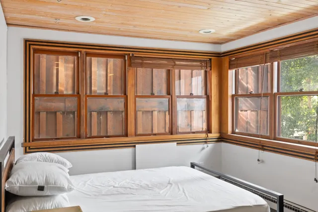 a bedroom with a bed and a large window