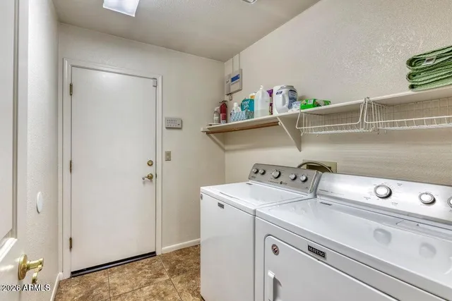 a view of washer and dryer with kitchen in the background
