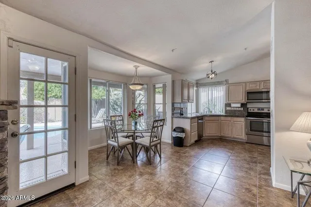 a large white kitchen with lots of counter top space and stainless steel appliances