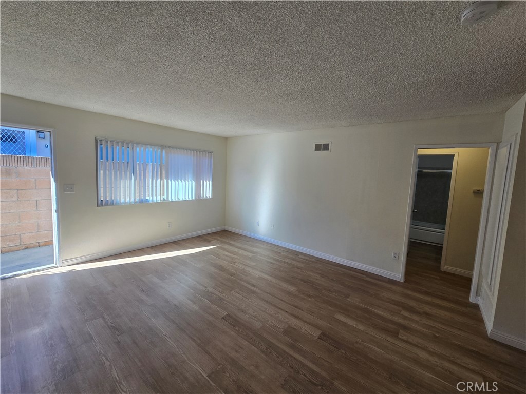 2718 Florida Street, Unit B Huntington Beach, CA 92648 - Photo 3 of 18 an empty room with wooden floor and windows
