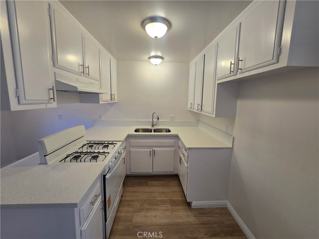 2718 Florida Street, Unit B Huntington Beach, CA 92648 - Photo 4 of 18 a kitchen with a sink a stove and cabinets