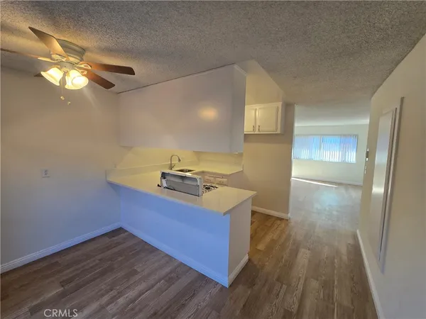 a kitchen with wooden floor and cabinets