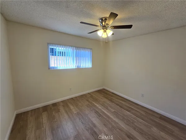 a view of empty room with window and wooden floor