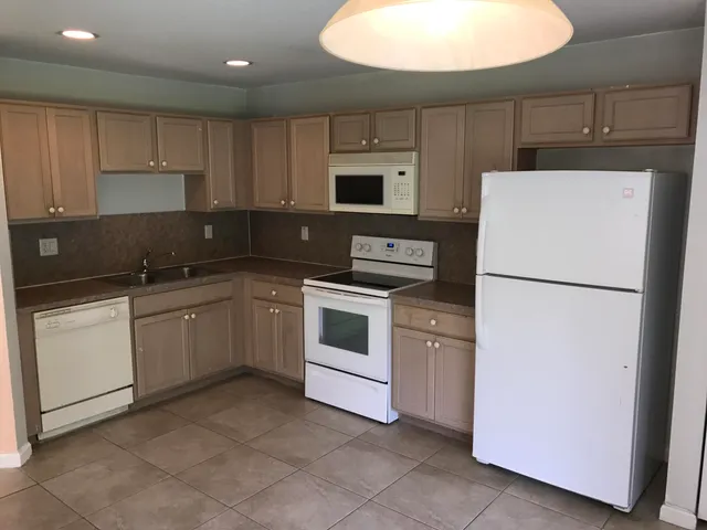 a kitchen with a white stove top oven and white cabinets