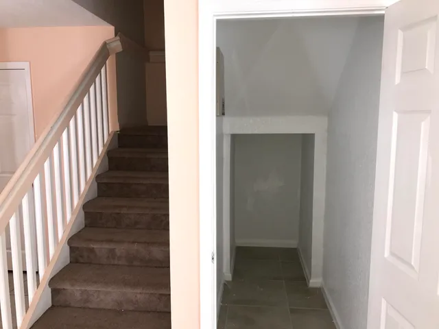 a view of a hallway with wooden floor and entryway