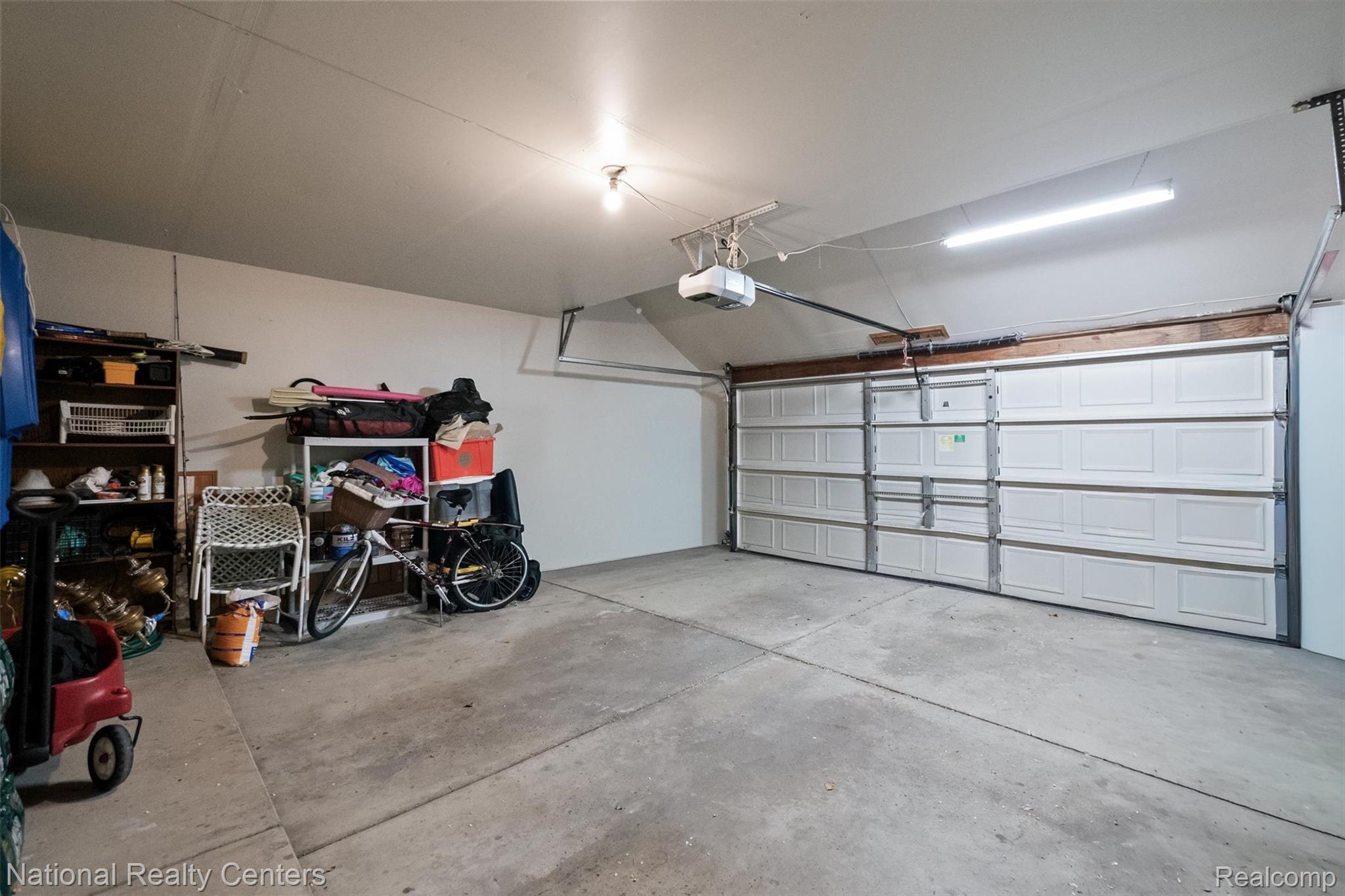 2203 Rochelle Park Drive Rochester, MI 48309 - Photo 41 of 43 Spacious garage featuring a concrete floor, white panel garage door, and ample overhead lighting