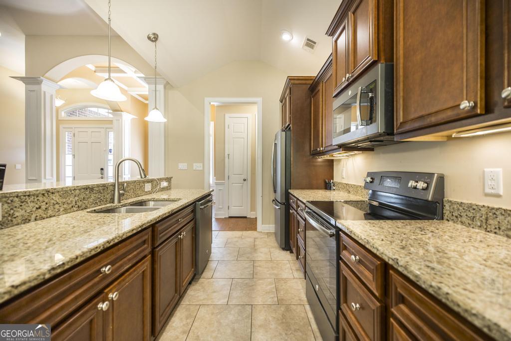 206 Londe Lane Perry, GA 31069 - Photo 12 of 37 a large kitchen with granite countertop a sink and dishwasher a stove top oven with wooden floor