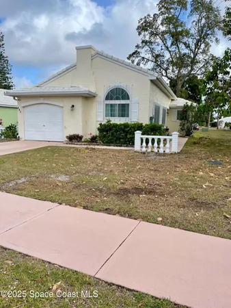 a view of a house with a yard and potted plants
