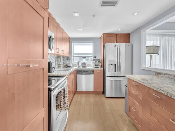 a kitchen with a refrigerator a sink and a stove top oven