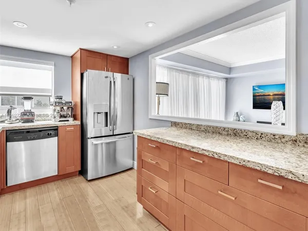 a kitchen with granite countertop stainless steel appliances a refrigerator sink and microwave