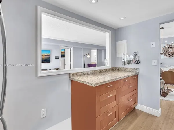 a bathroom with a granite countertop sink and a mirror