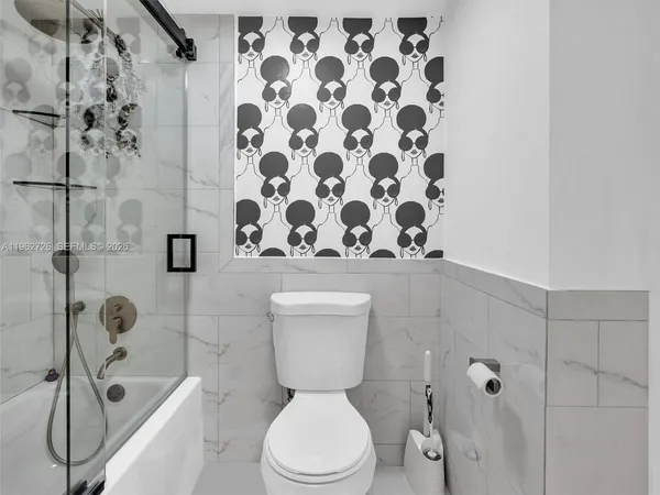 a white toilet sitting next to a bathroom sink