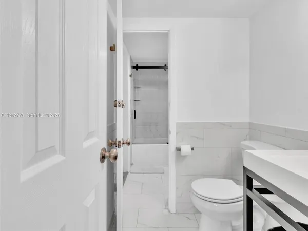 a bathroom with a granite countertop toilet a sink and shower