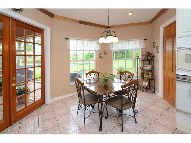 18951 Southwest 51st Manor Southwest Ranches, FL 33332 - Photo 21 of 27 a view of a dining room with furniture wooden floor and chandelier