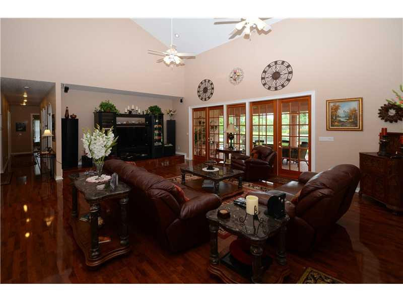 18951 Southwest 51st Manor Southwest Ranches, FL 33332 - Photo 8 of 27 a living room with furniture a chandelier and a flat screen tv