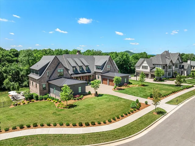 a view of a house with small yard plants and a garage