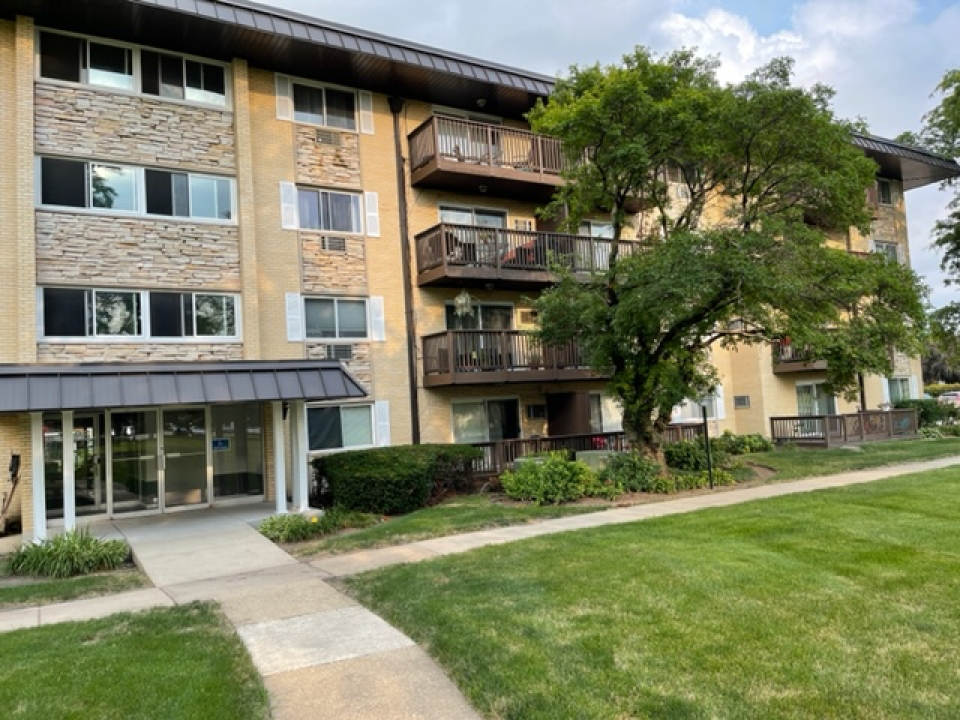 2226 South Goebbert Road, Unit 270 Arlington Heights, IL 60005 - Photo 1 of 19 a front view of a residential apartment building with a yard