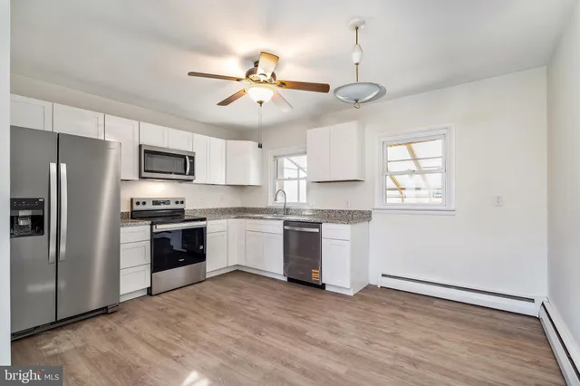a kitchen with a refrigerator and white cabinets