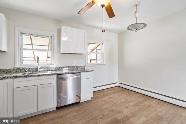 a kitchen with granite countertop white cabinets and white appliances