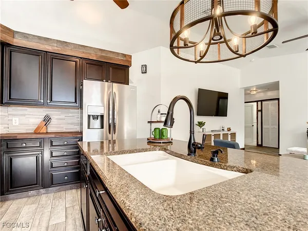 a kitchen with kitchen island granite countertop a stove a sink and a microwave
