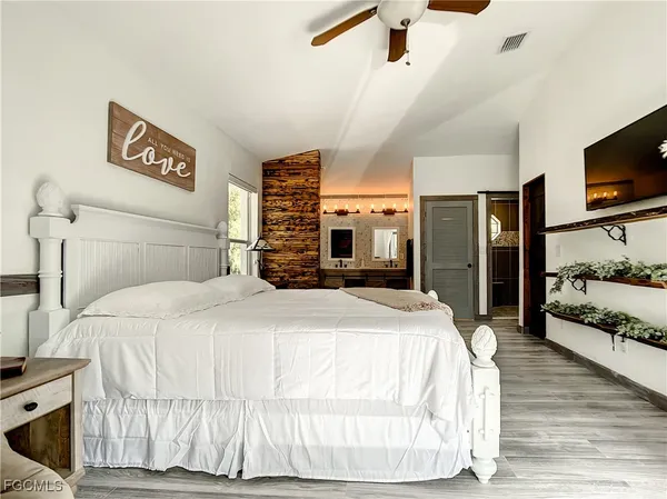 a bedroom with a bed and a flat screen tv