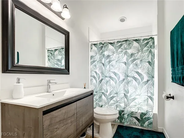 a bathroom with a sink toilet and mirror