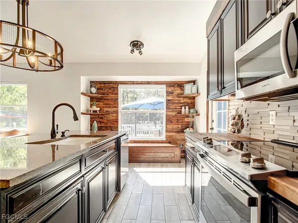 a kitchen with stainless steel appliances a sink stove and cabinets
